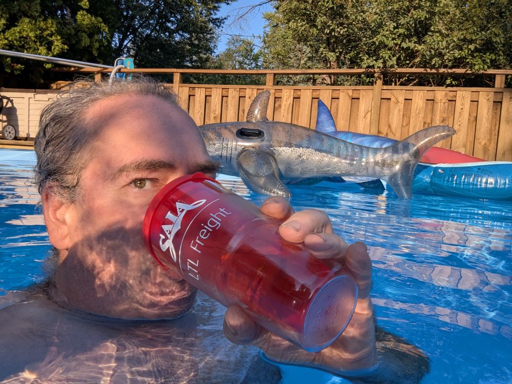 Me in the pool with the blowup sharks, and a whiskey and ginger ale in the insulated glass.. that's my employer on the sippy cup, if you ever see one of my drivers doing something's ng stupid, be sure to let me know...
