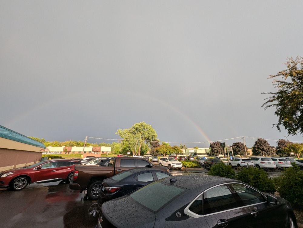 Faded rainbow with a bit of a second rainbow from a parking lot in Vandais Heights