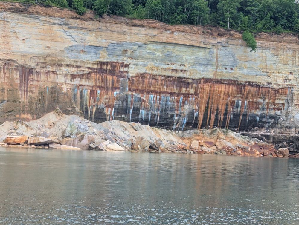 Different minerals leaching from the rocks stain the cliff with a variety of colors