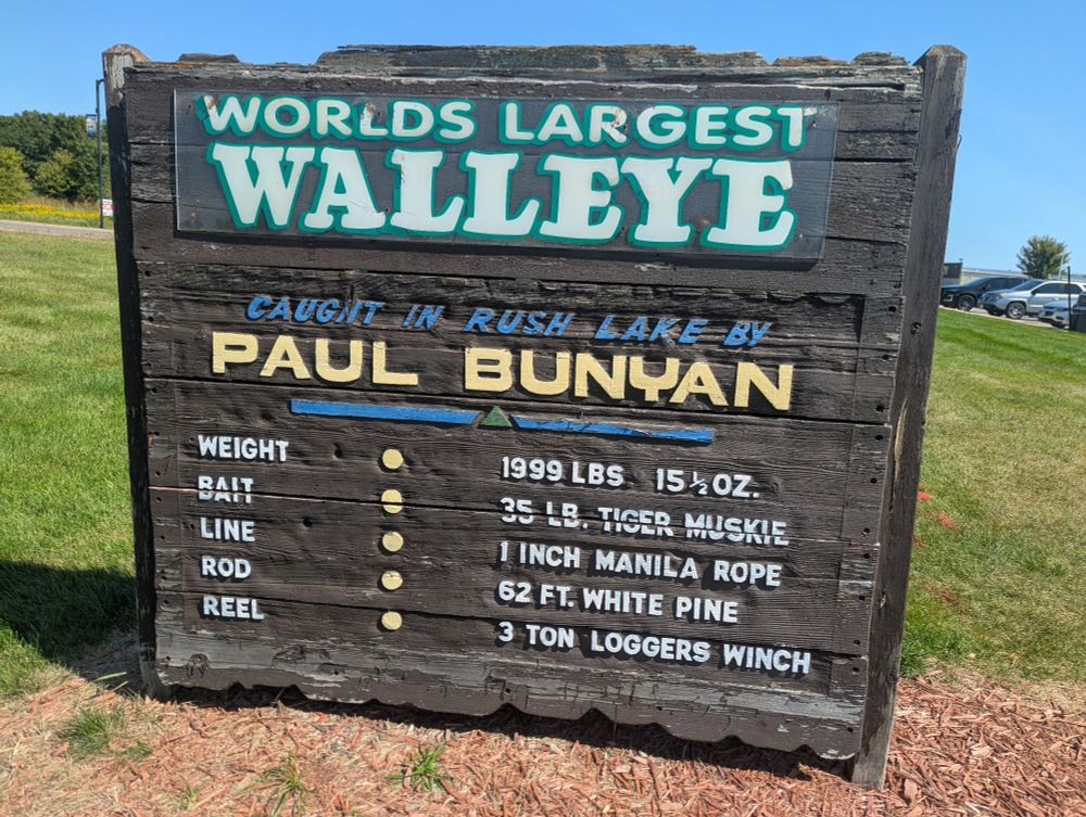 Sign saying World's Largest Walleye, caught in Rush Lake by Paul Bunyan. Weight 1999 lbs, 15 and a half ounces. Bait 35# tiger muskie. Line 1
