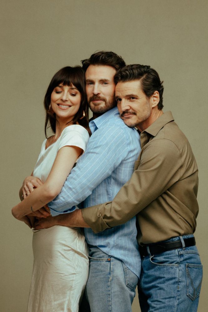 Chris Evans, Dakota Johnson, and Pedro Pascal in promotion photos for the upcoming movie The Materialists. Chris is in the middle with his arms around Dakota’s waist while Pedro has his arms around them both from behind.