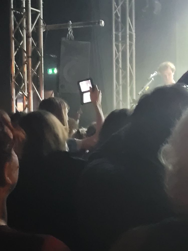 Personne dans la fosse qui brandit un ds pour prendre des vidéos.