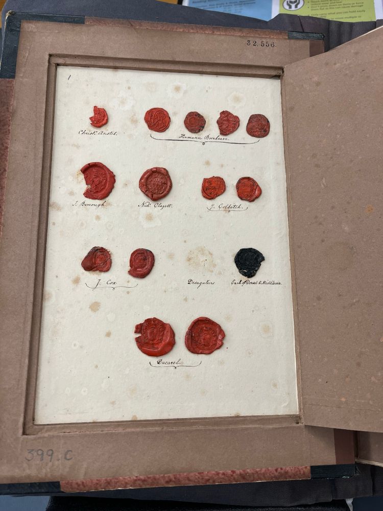 A set of red wax seals for individuals and family. There are seals various sizes stamped out inside the hidden compartment. Most of the seals are cracked or damaged in some way, and one is missing entirely.