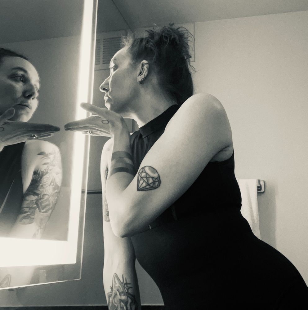 A person blows a kiss in the mirror.