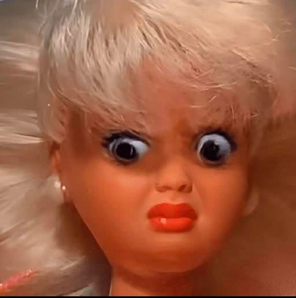 a barbie doll whose face is a little bit smooshed making her look revolted and terrified