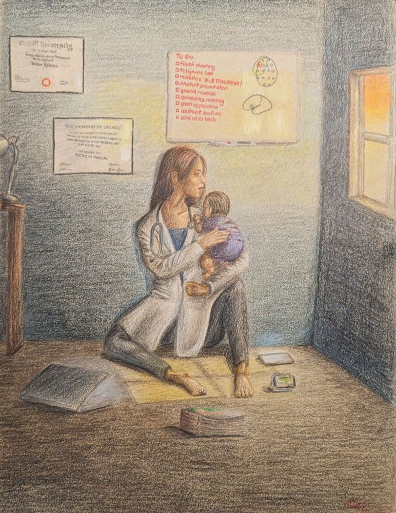 A female physician sits against a wall while holding her baby. The sun is setting outside and the light shines through a window in the darkened room. Her diplomas and white board with tasks are on the wall above where she sits. Her pager, phone, and laptop around her on the ground.