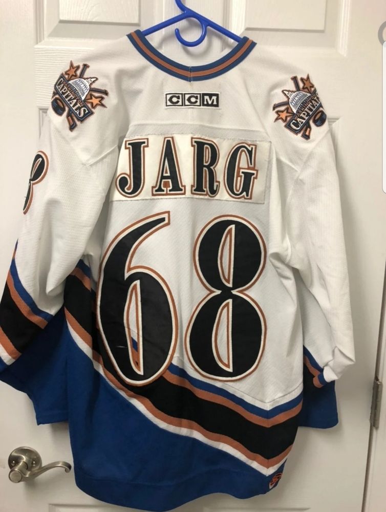 A Washington Capitals CCM white screaming eagle jersey with the number 68 on the back and the name JARG over it. 