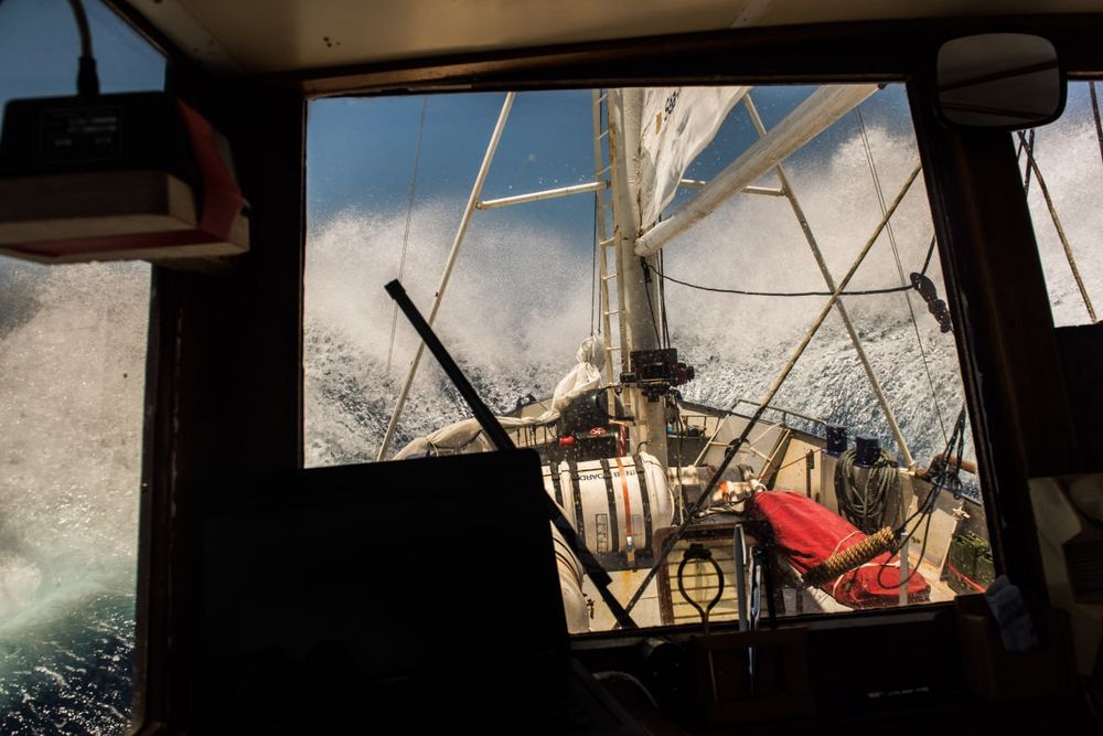 Man sieht Gischt vor dem Bug der Sea-Watch hoch schiessen, von der Brücke aus fotografiert.