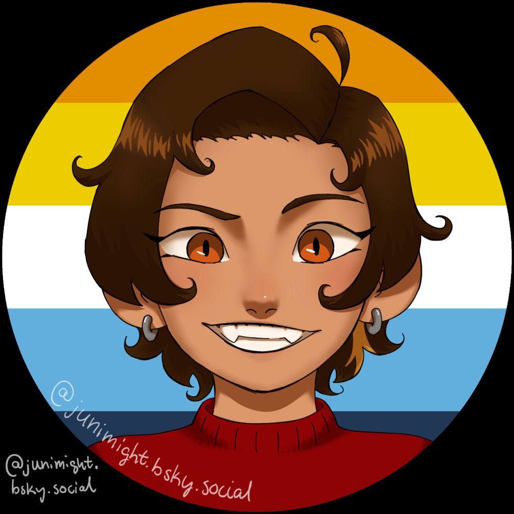 A profile picture of a brown-haired and lightly tanned person in front of an aromantic-asexual flag. They have a wide smile which shows off their chunky and prominent canine teeth. Their eyes are an orangey brown and have vertical pupils that look like rounded slits. Their hair is cut at the ears with some longer at the back. The ends of it curl slightly. A little streak of hair behind their left ear is blond. They are wearing silver sleeper hoop earrings. They are wearing a red sweater.