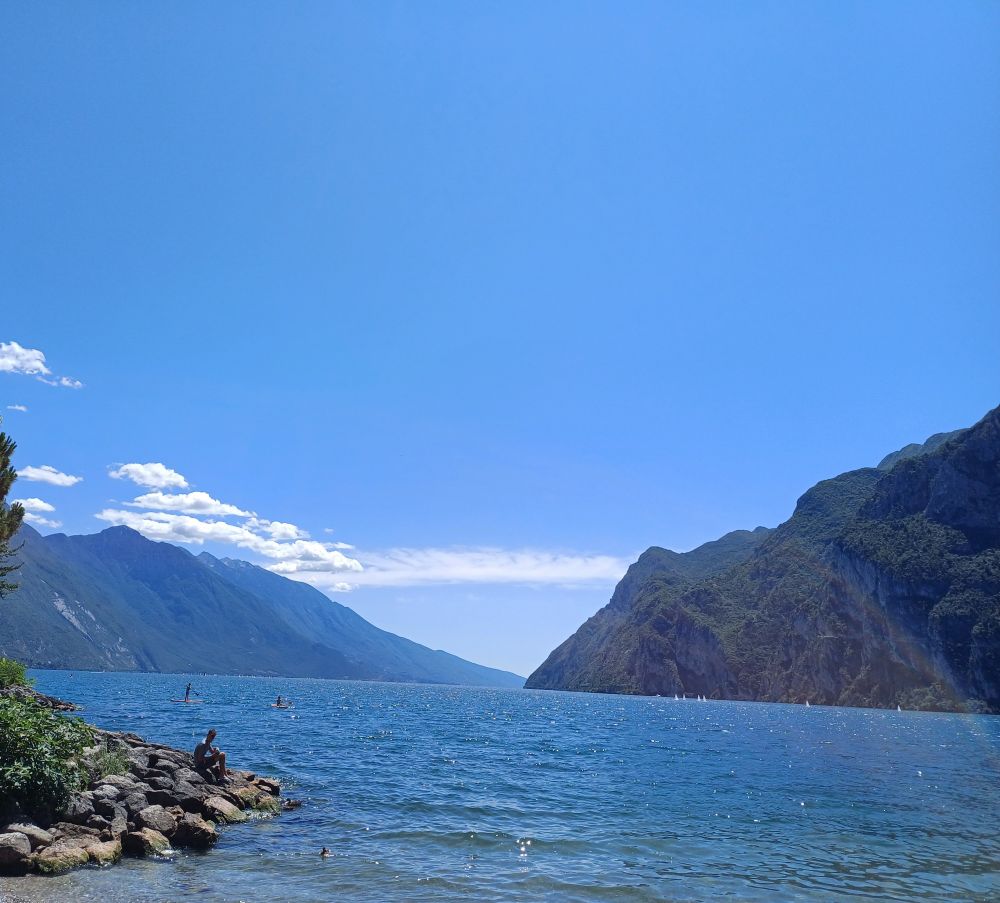 Blue Lake Garda, surrounded by the mountains and with blue sky overhead
