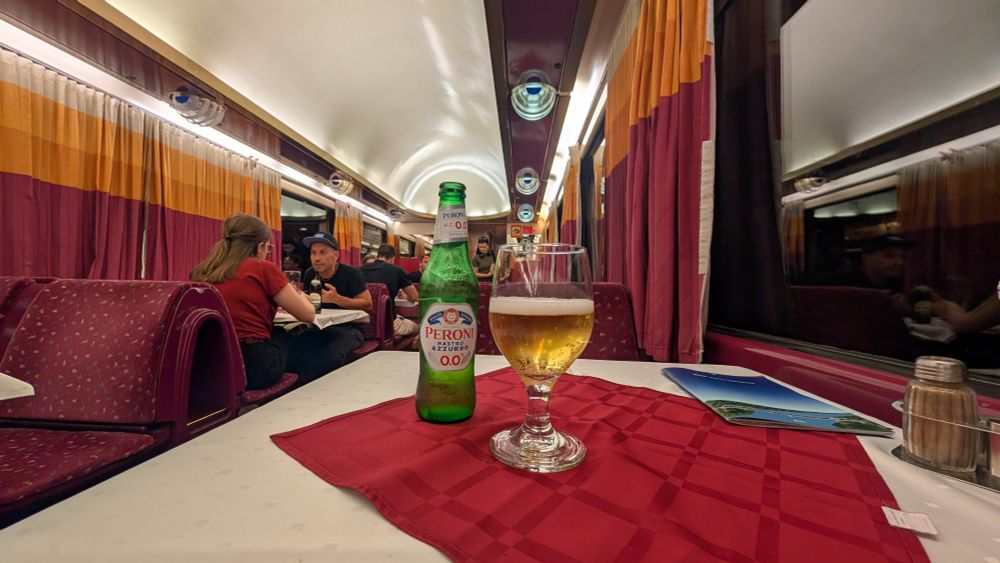 Flasche und Glas mit Bier Peroni 0.0 auf dem Speisewagentisch