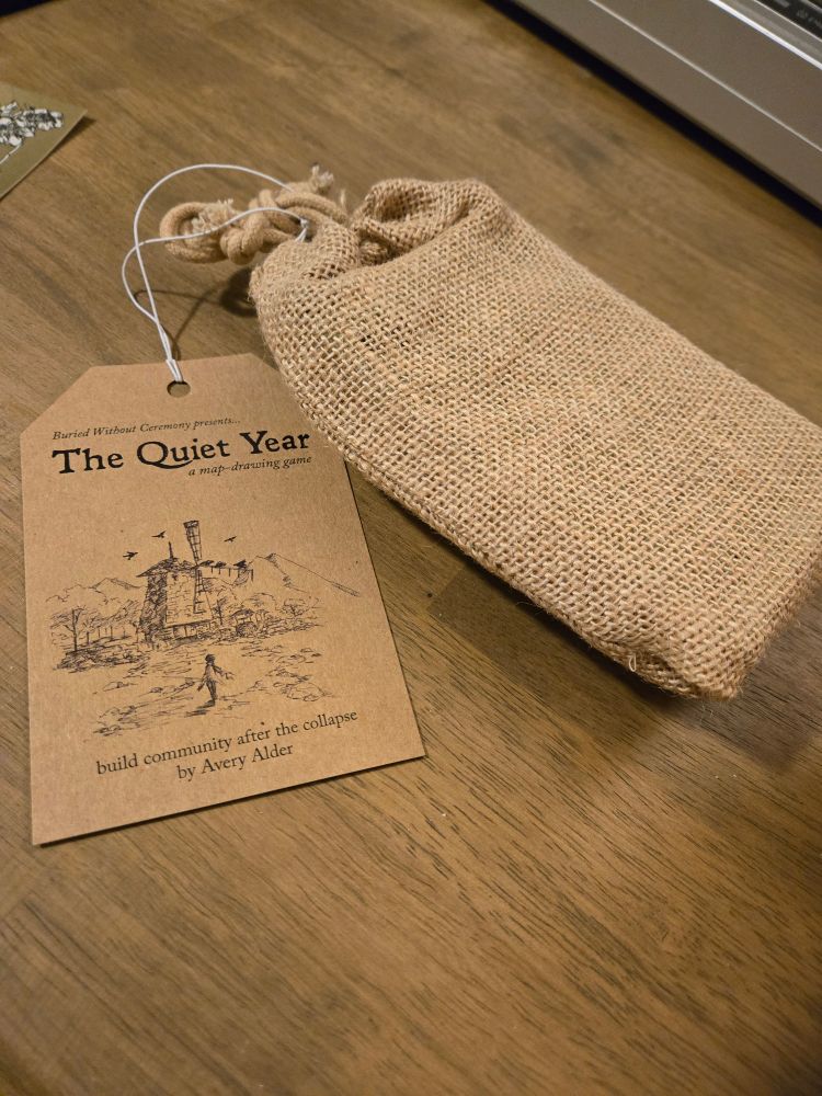 A Quiet Year art tied to burlap bag containing the game