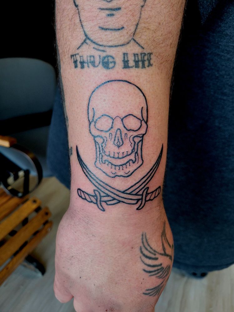 Photo of a skull and crossed swords tattoo
