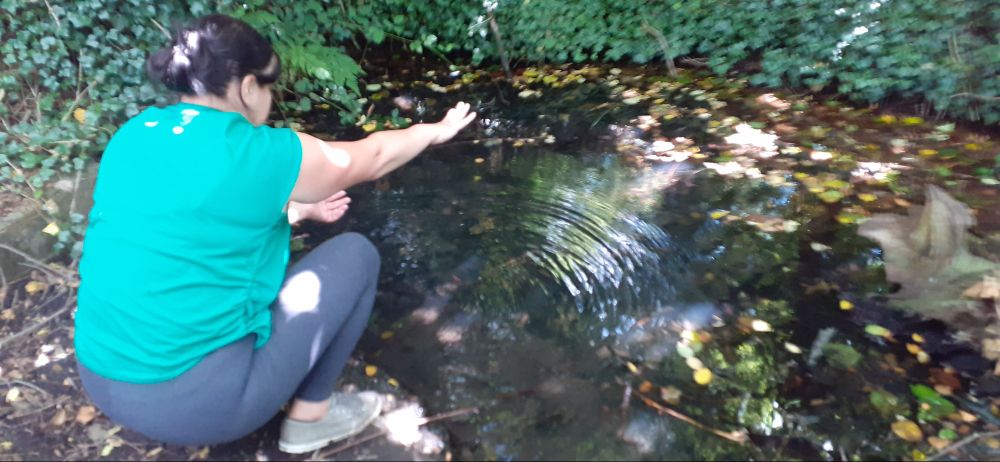 Laura, making an offering to The Running Well, Essex.