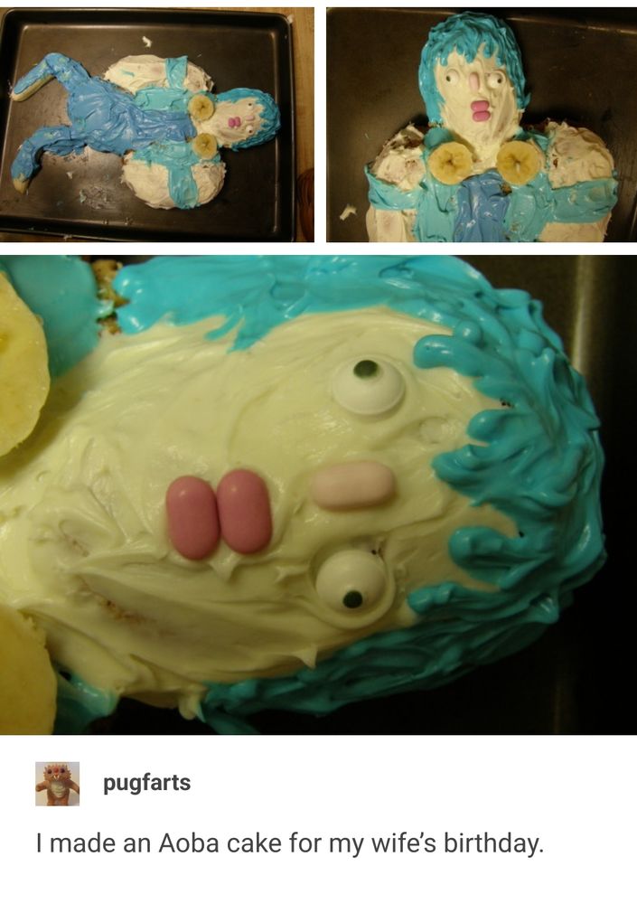 A picture of a wonky cake vaguely resembling Aoba from DMMD. His lips and nose are pink tictacs, and his sugar eyes are cross eyed. There is so much icing.