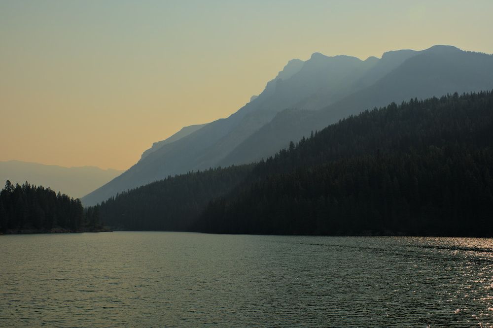 View of Lake Minnewanka and surrounding mountains in Banff national park, on a smoky day due to forest fires