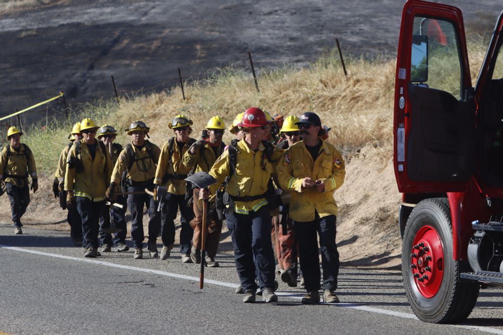 CAL FIRE firefighters walk towards an engine