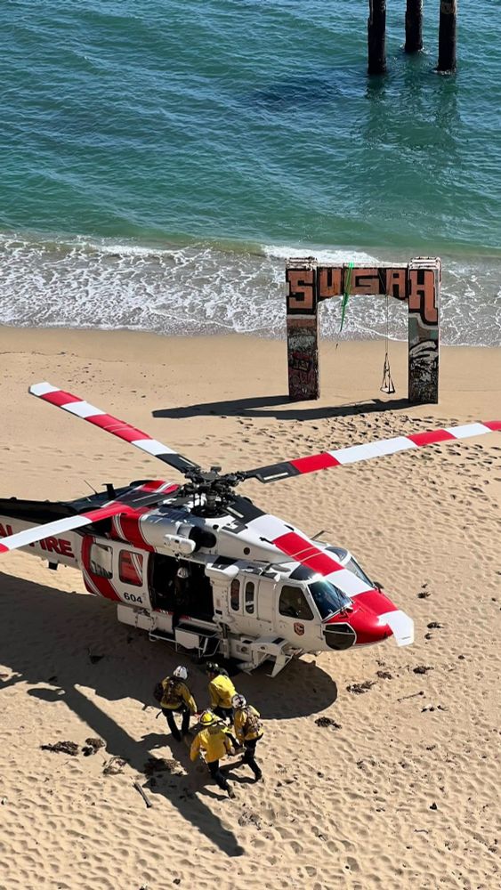 CAL FIRE helicopter land on the beach to perform a rescue