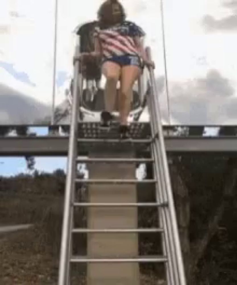 a woman in an american flag shirt is riding a roller coaster down a set of stairs .