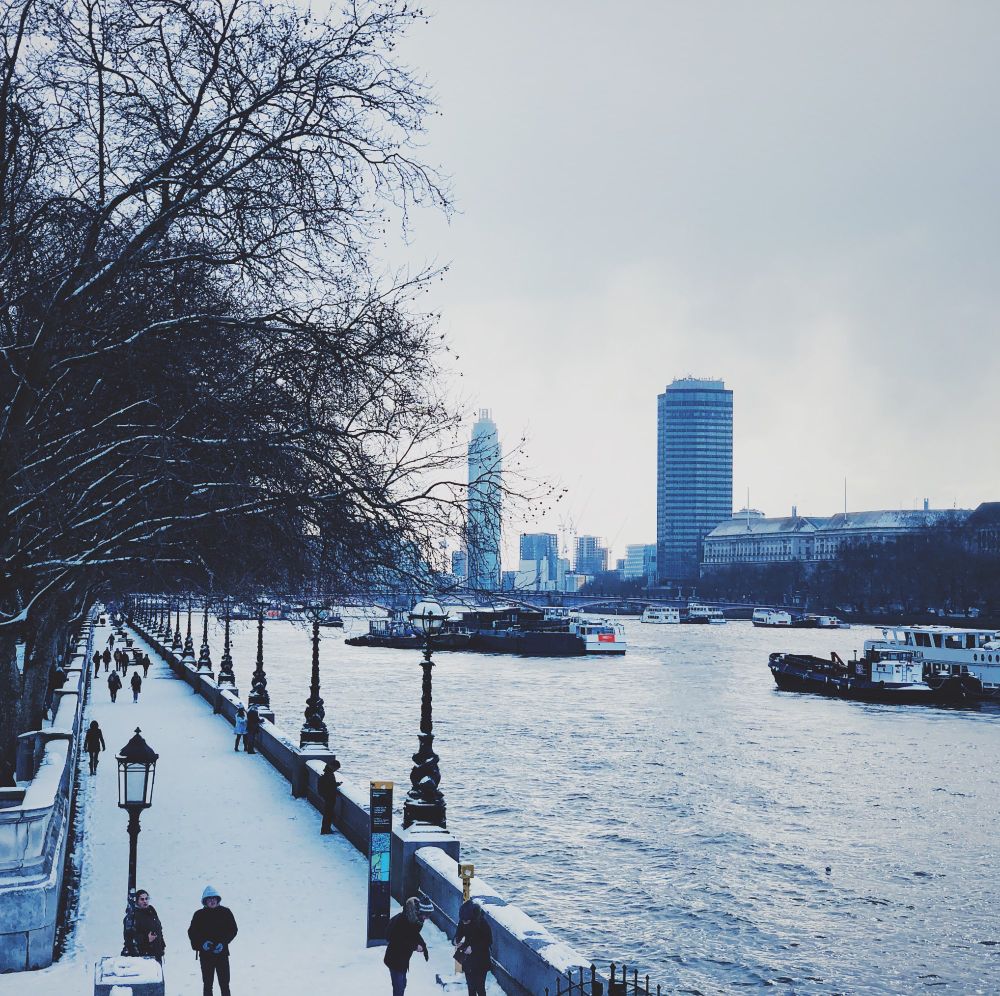 The Albert embankment covered in snow next to the river thames.