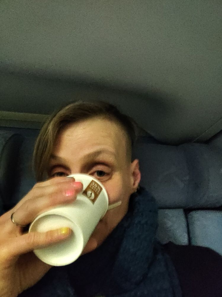 Me with a cup of coffee in my face, early morning on the train