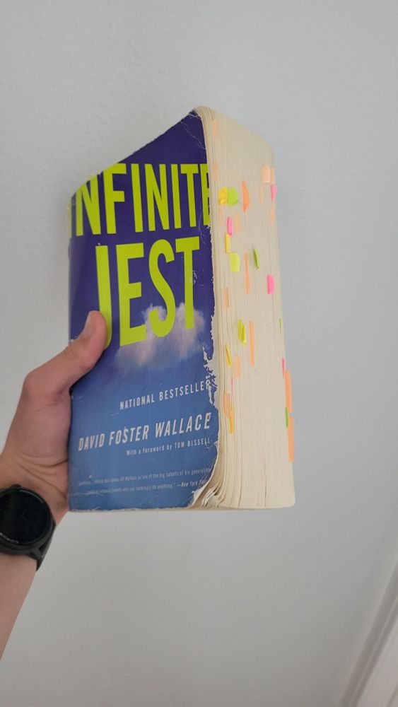 Weathered copy of Infinite Jest with a lot of sticky notes coming out of the side