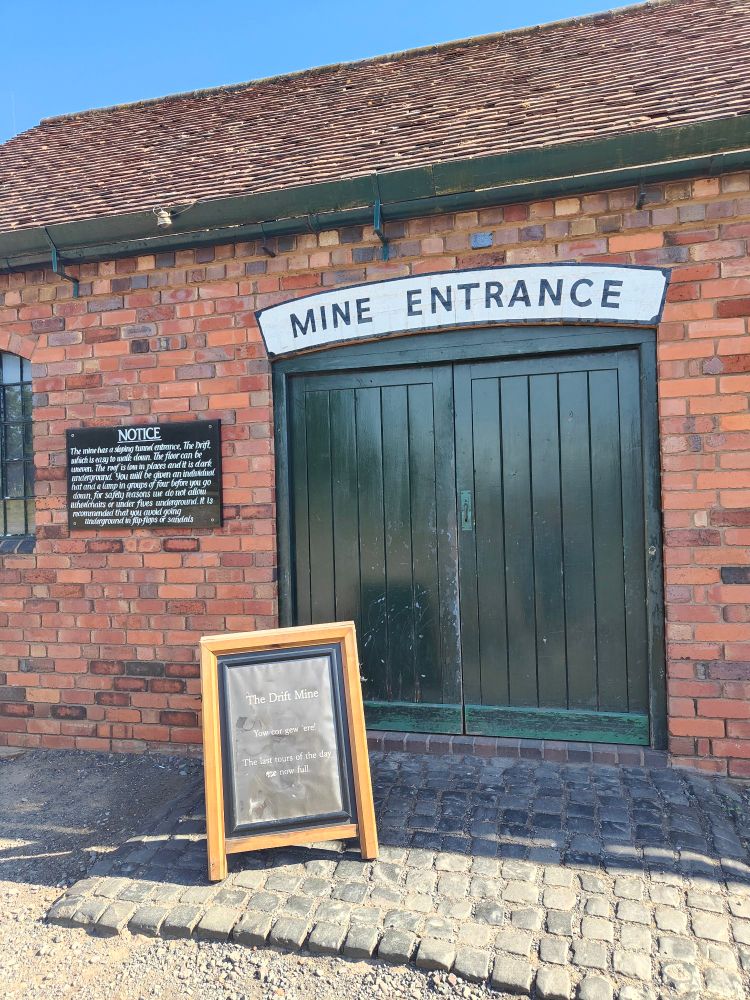 Mine entrance - a brick building with green double doors which are closed 