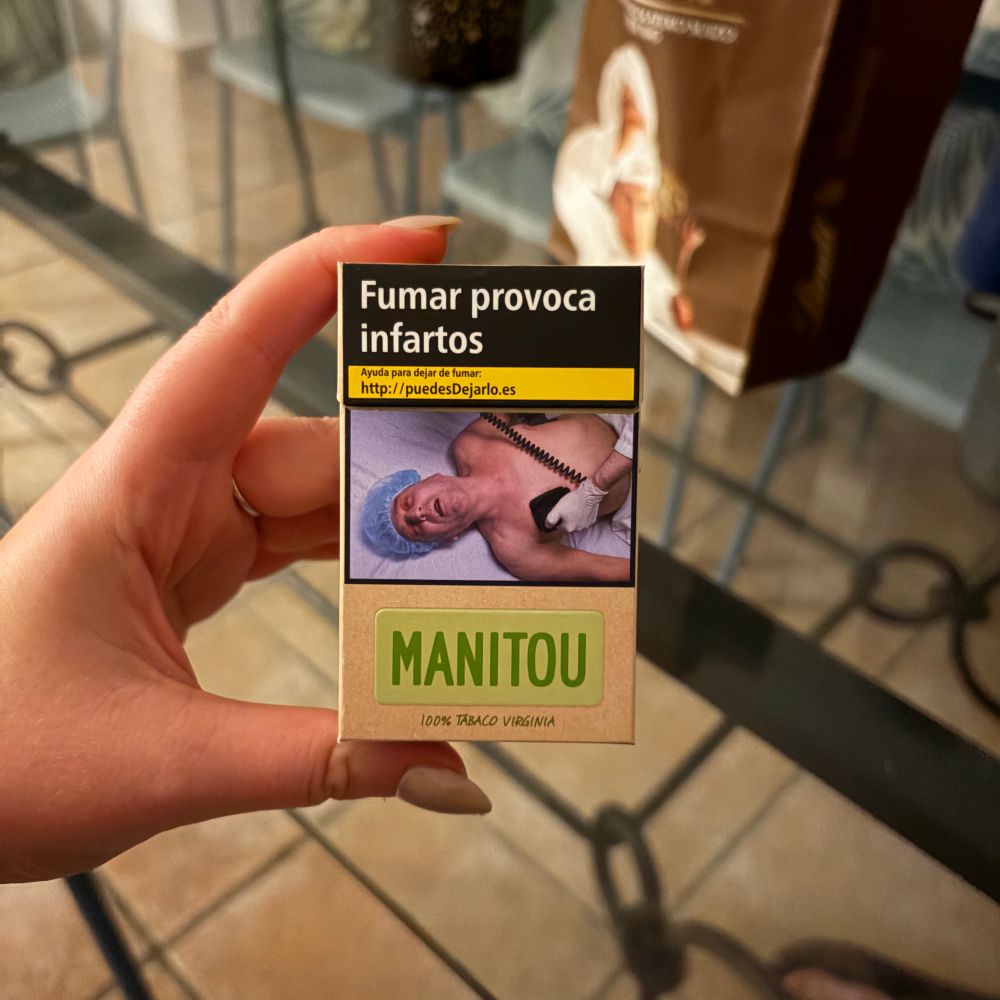 a box of cigarettes with a big picture of an ill looking man getting his heart shocked and the text says “Fumar provoca infartos” which translates to “smoking causes heart attack”