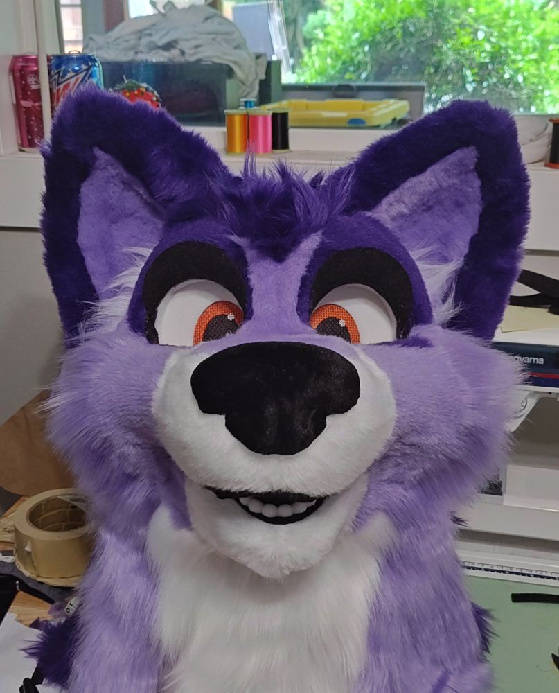 A smiling purple and white fursuit!