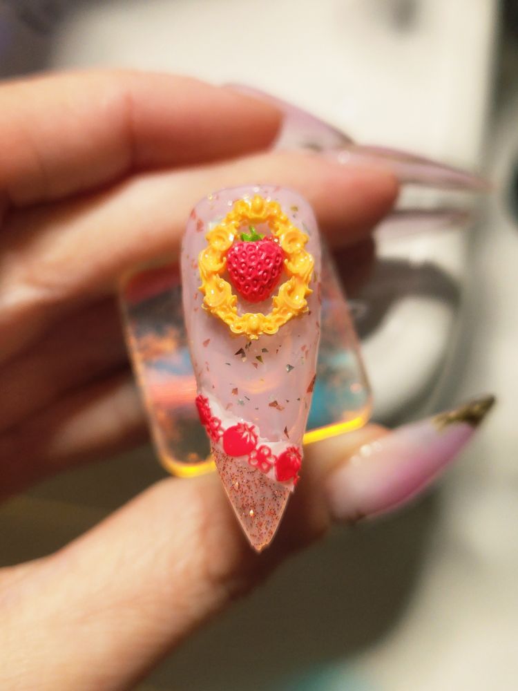 Fake nail design. Pink with red glitter tip. Strawberry lace pattern to pink glitter. Yellow frame in centre with strawberry charm