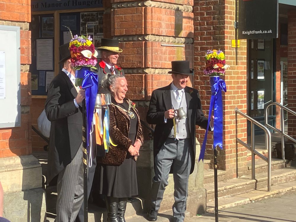 Constable, tuttimen, with their flowered & beribboned tuttipoles & ale jugs, tutti girls and boys & orangeman, assemble on Town Hall steps before setting off to collect tithes, & exchange kisses and oranges. 