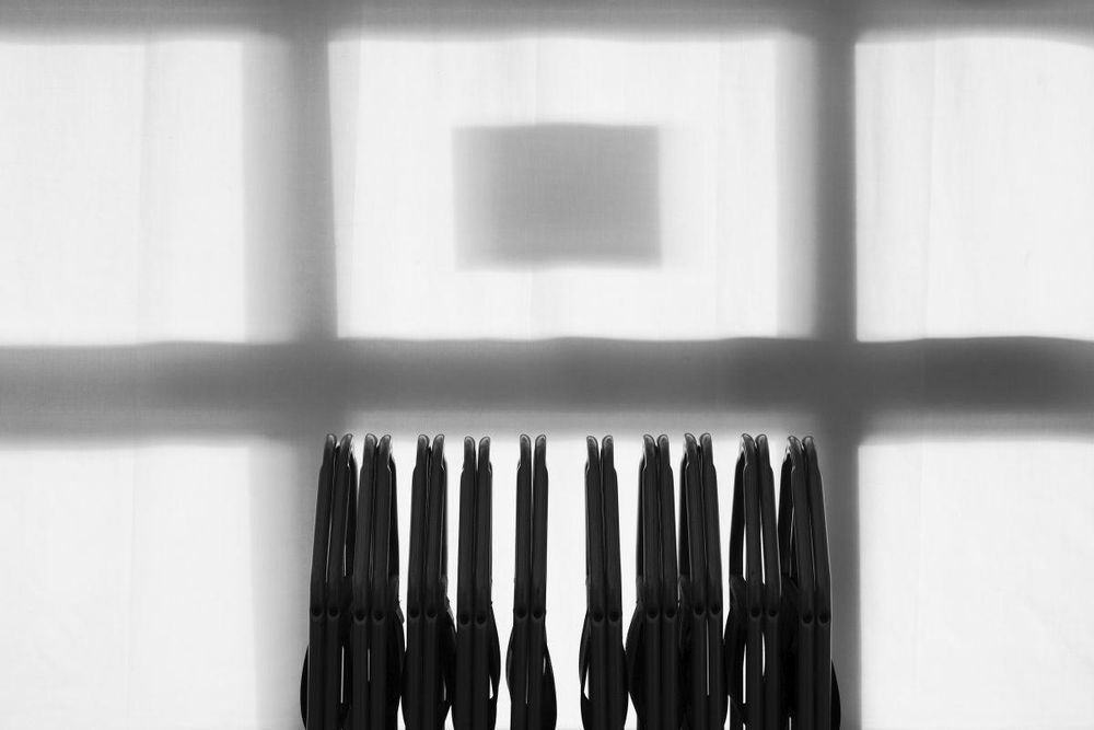 A square inside a square in a window, a row of folding chairs below