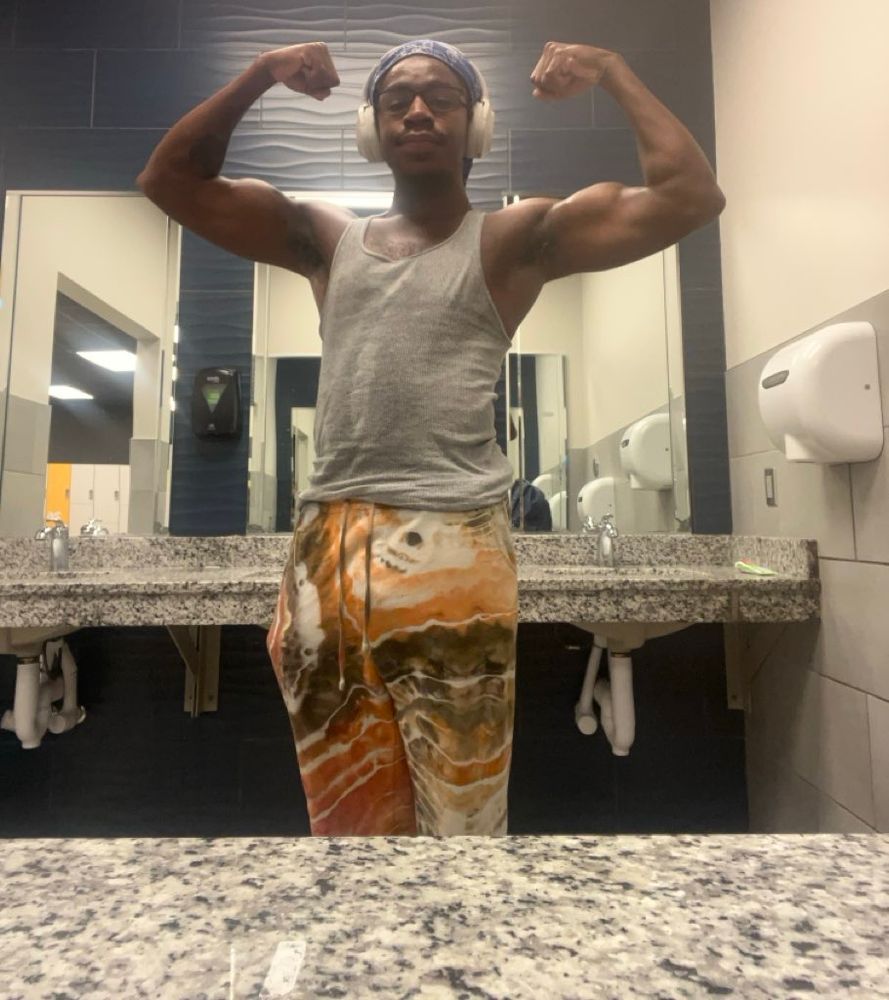 Mirror selfie of a man flexing his arms