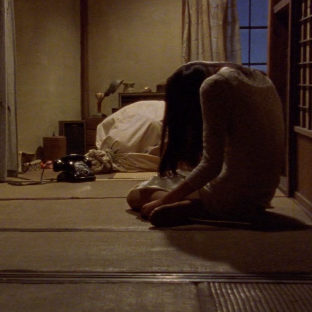 Shot from Audition where a woman is sitting motionless on the floor, with a phone and a tied up sack in the background. In context it's horrifying because the first hour of the film has been essentially a romantic comedy, and as the protagonist is about to call his putative romantic partner, we cut to her waiting motionless on the floor for him to call, with the implication that she's been sitting there motionless for hours, if not days. As soon as the phone starts ringing, the bag behind her starts writhing silently, with something alive inside it.