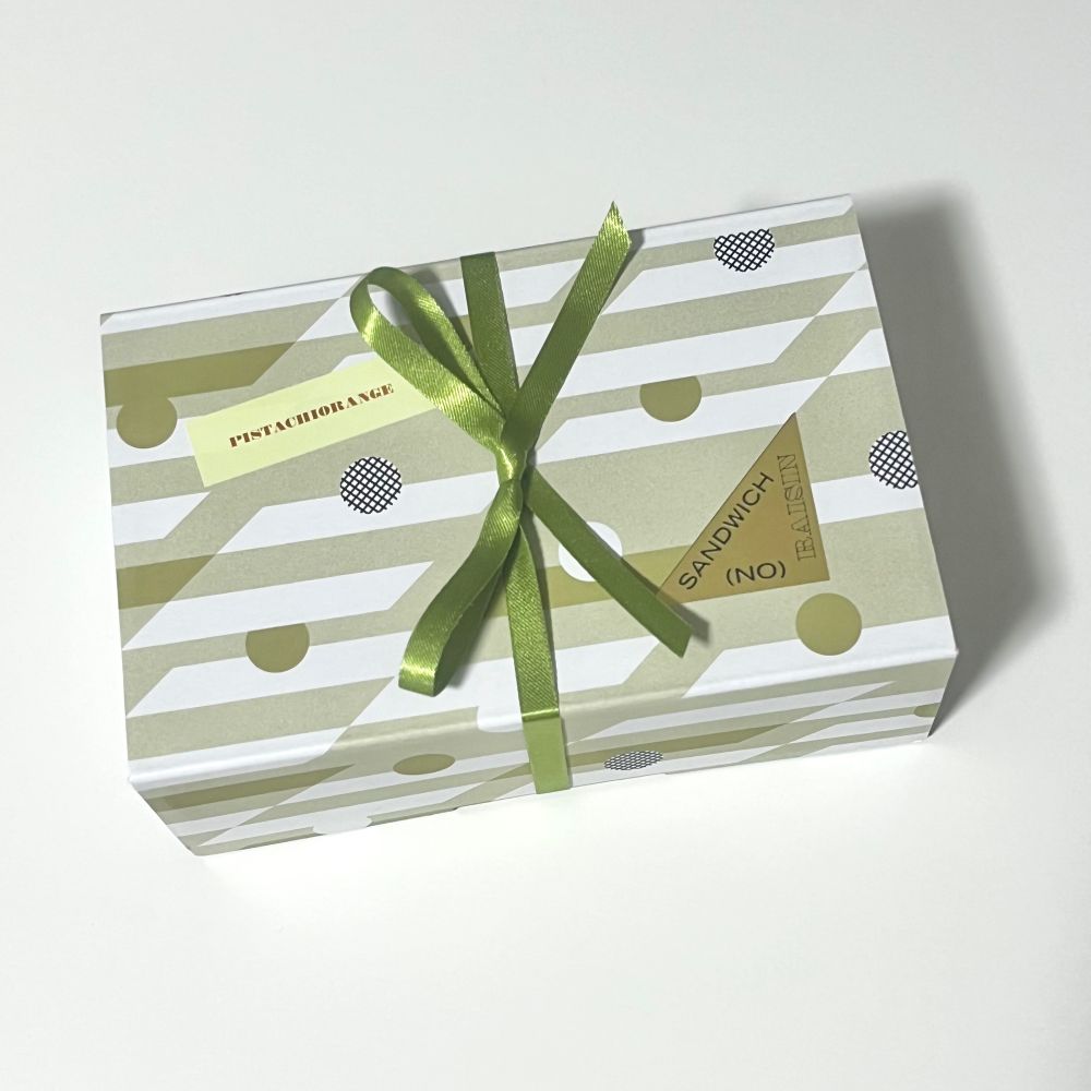 (NO) RAISIN SANDWICHのピスタチオレンジのボックス
グリーンのリボンがかかっていて、(NO) RAISIN SANDWICHのロゴシールとPISTACHIORANGEと描かれたシールが貼ってある