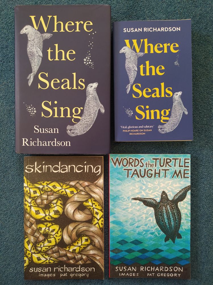 Four books by Susan Richardson are laid out in a square configuration against a blue background - the hardback and paperback versions of her work of creative non-fiction, Where the Seals Sing, and two of her poetry collections, skindancing and Words the Turtle Taught Me. 