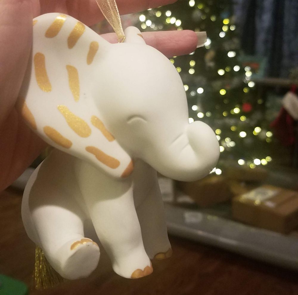 A close-up of a white and gold, porcelain elephant ornament.