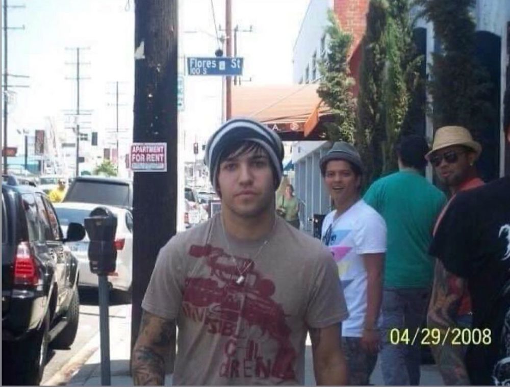 Photo of three men in similar position to that "distracted boyfriend" meme, except Bruno Mars is distracted by Pete Wentz on a sidewalk. Photo dated 4/29/2008