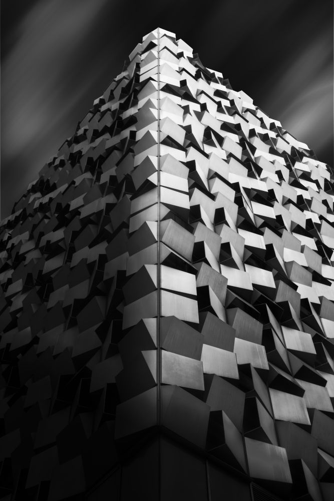 A monochrome high-contrast architecture photograph of the "cheese grater" in Sheffield city centre, UK.  A simulated long-exposure sky has been implemented in post-processing.