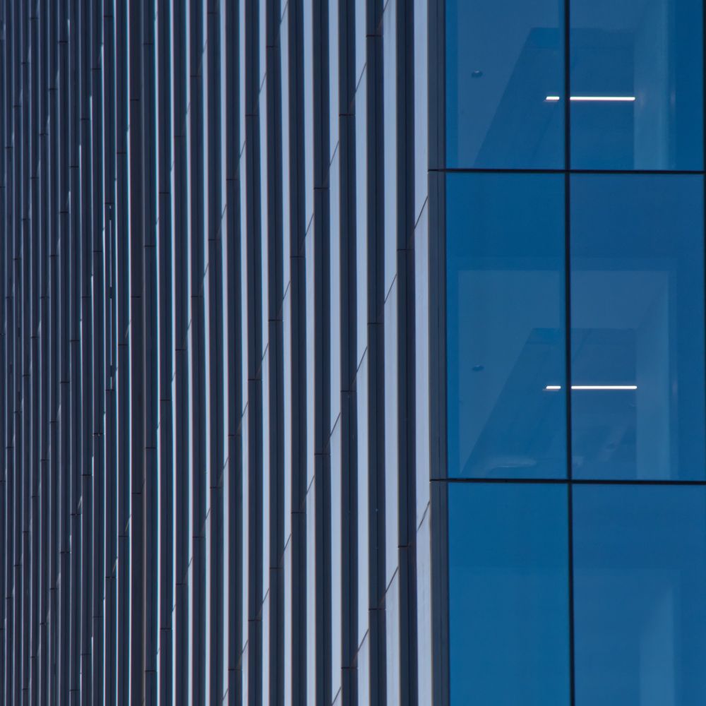An abstract architecture photo mostly in blue and black with little highlights.
