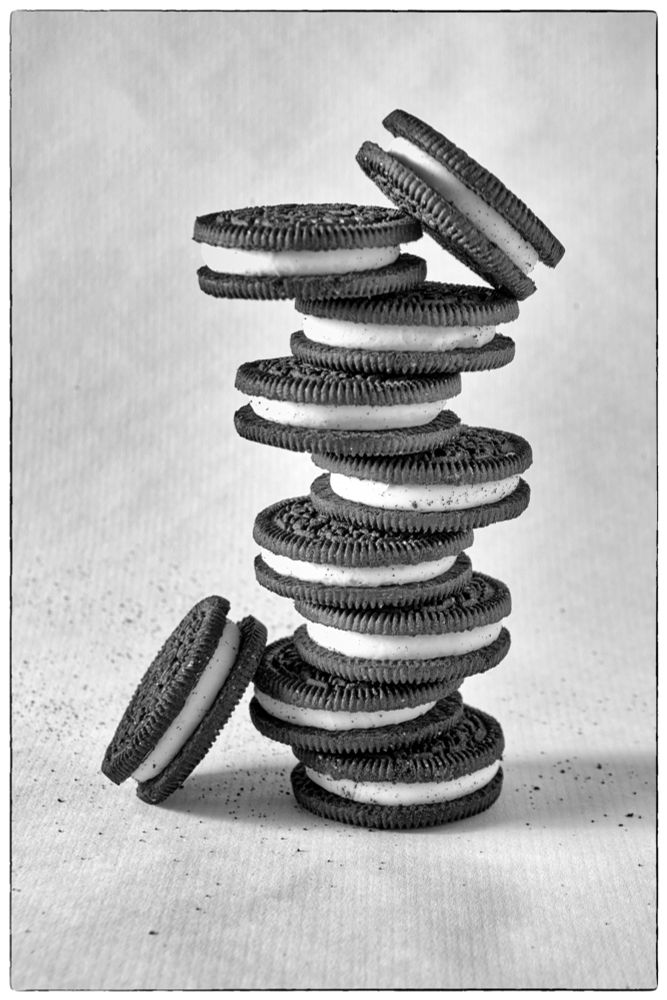 Oreo biscuits stacked in a precarious balance, presented in monochrome.