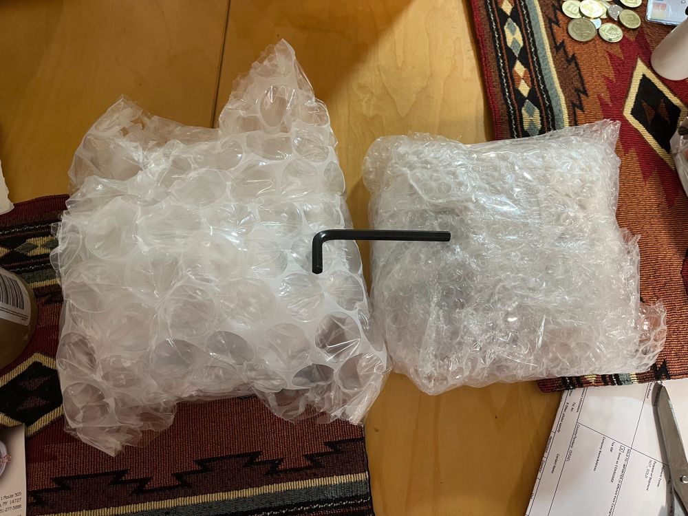 Two roundish objects wrapped in bubble wrap and an allen wrench