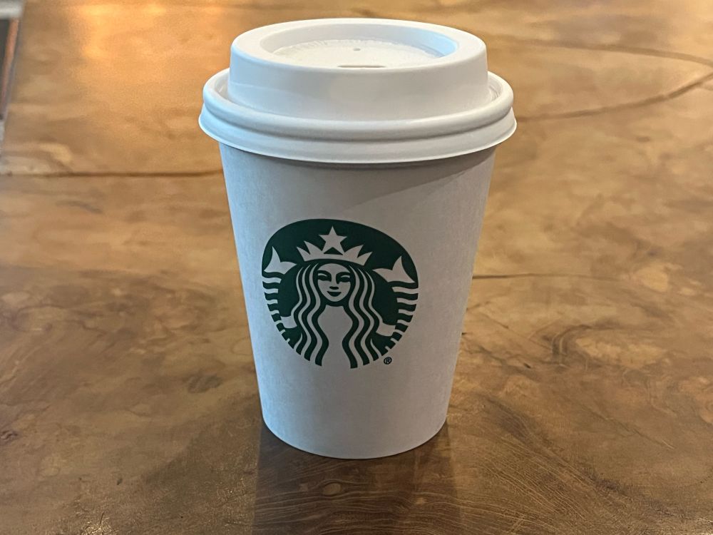 A Starbucks coffee cup containing a plain latte