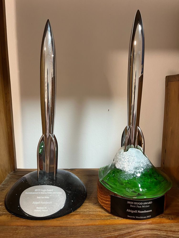 The 2017 and 2025 Hugo awards for best fan writer, awarded to Abigail Nussbaum, side by side