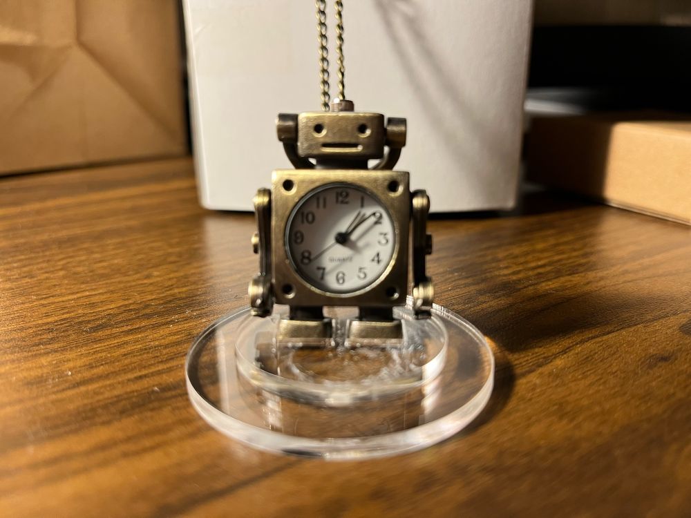 Robot statuette that is also a clock and can be worn as a pendant.