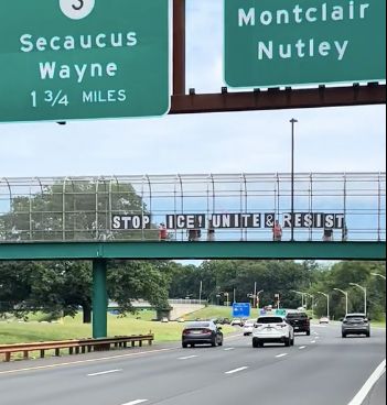 Letters on an overpass reading: Stop ICE Unite & Resist
