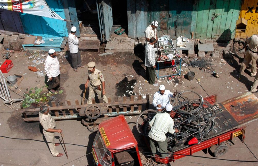Local residents and police officers clear debris at the blast site in Malegaon in 2008. Source: Reuters
