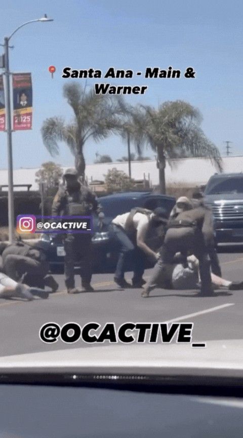 A screen grab from a social media video shows an officer using a baton on a man as he struggles on the ground. 