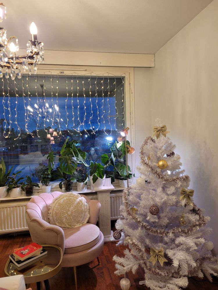 Vaaleanpunainen nojatuolinurkkaus on täydentynyt verhomallisilla kausivaloilla ja valkoisella kuusella, jossa kullan ja vaaleanpunaisen sävyiset koristeet. 