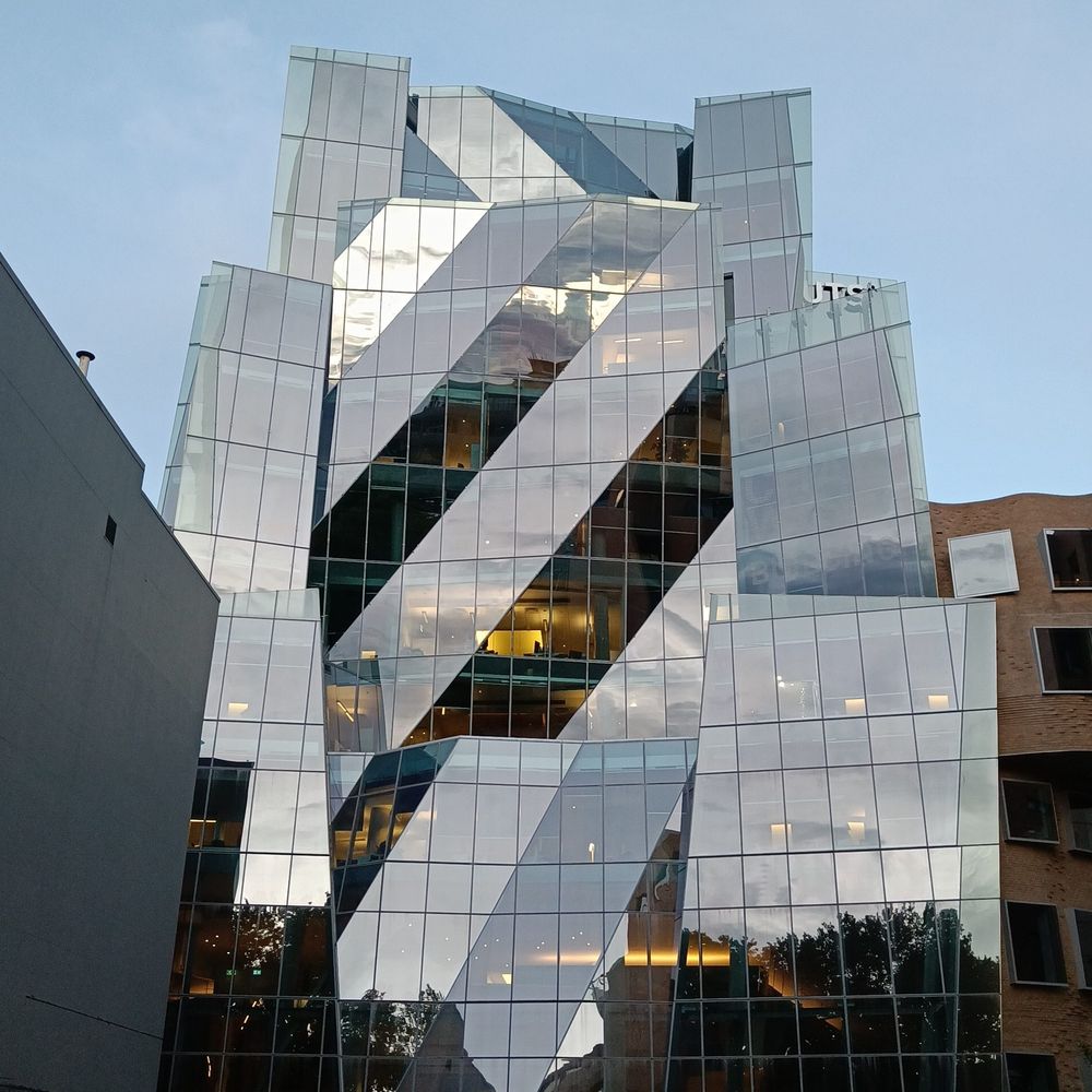ein Gebäude im nördlichen Bezirk von Sydney: gerade und schräge Linien, die Spiegelung der Landschaft in den Fenstern erzeugt unterschiedliche Bänder.